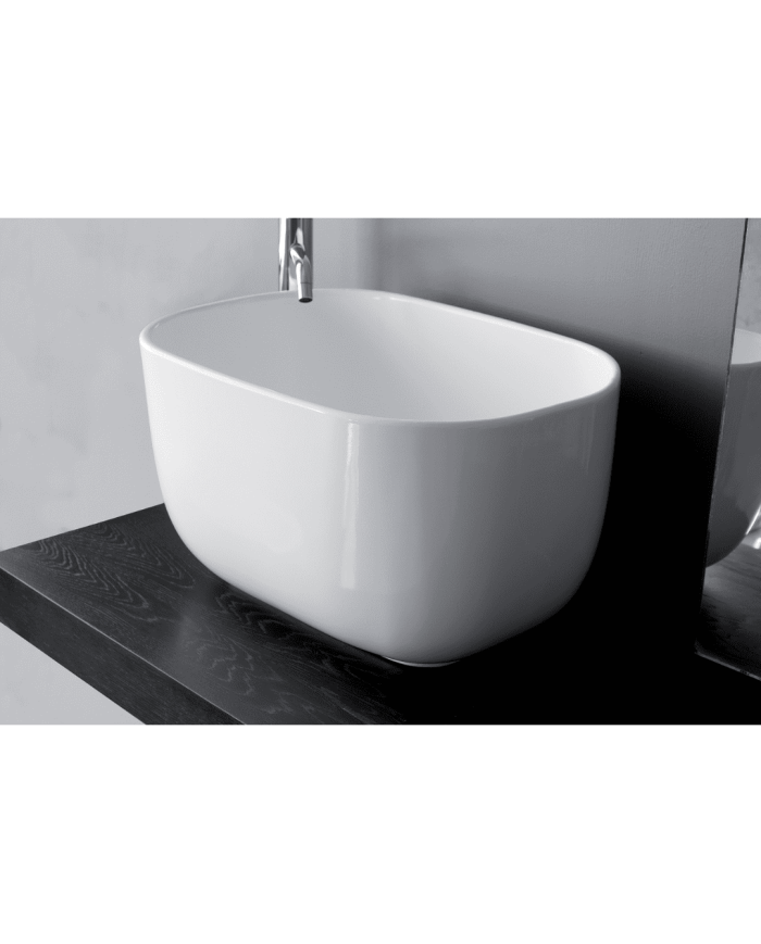 Lavabo Bowl 1 Bleu Provence en céramique blanche, design ovale, posé sur plan en bois sombre.
